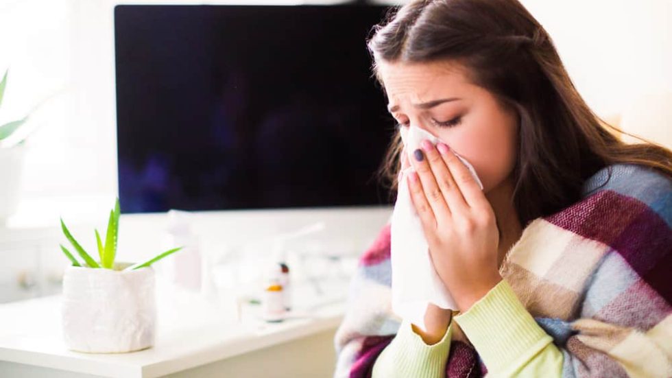 Side of woman with nasal congestion holding tissue